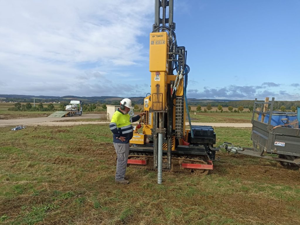 Un opérateur de GEOINTEC supervisant l'installation de vis de fondation pour des tests de charge dans un projet photovoltaïque en Europe.